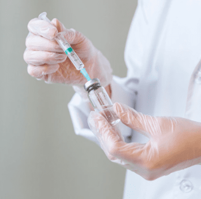 врач набирает в шприц лекарство для капельницы с антибиотиками